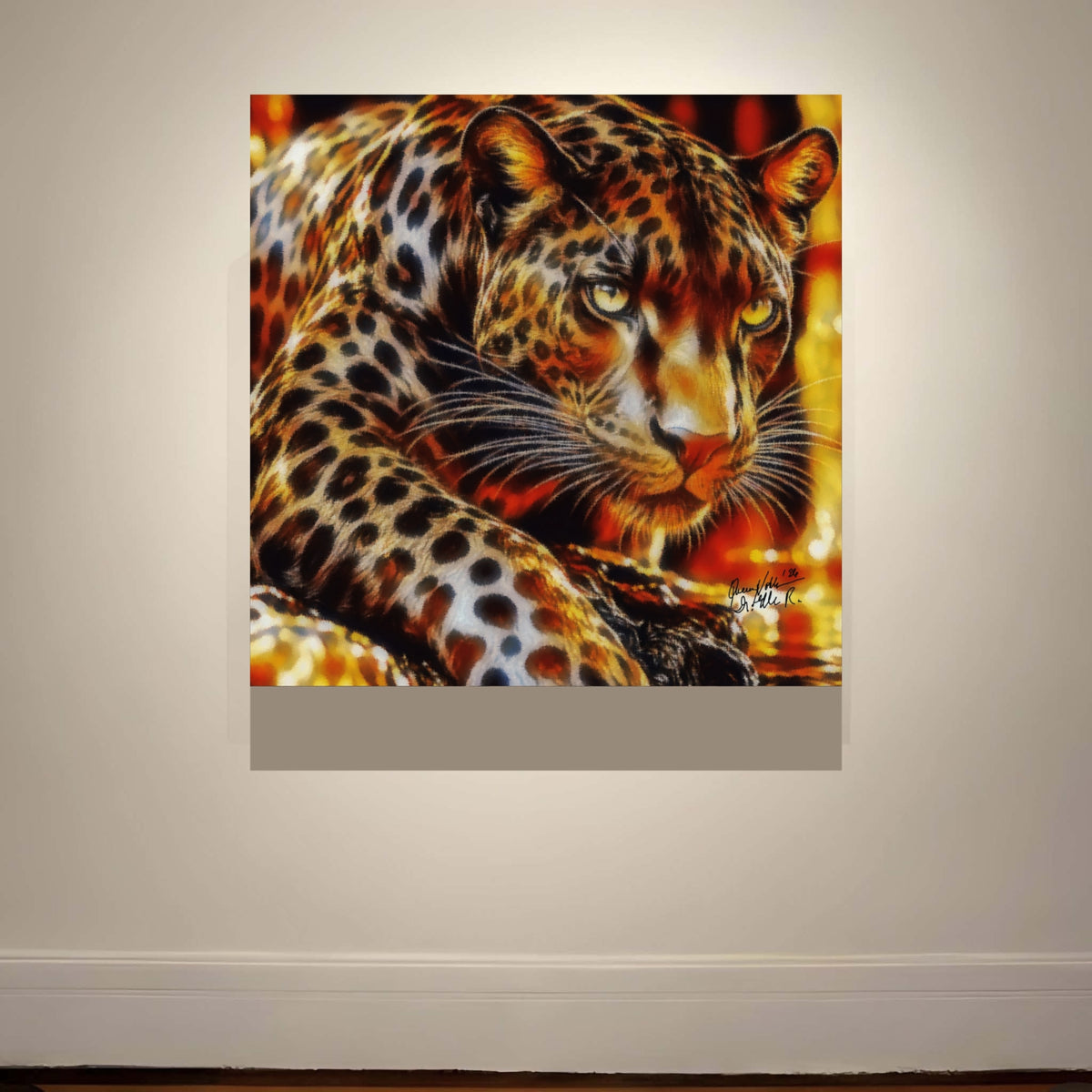A square wall art depicting a close-up leopard with striking yellow eyes and orange-brown fur spots, mounted on a light beige wall above a white baseboard.