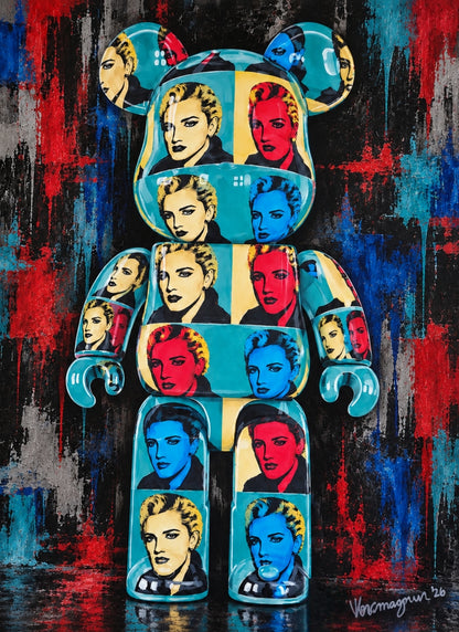A stylized bear-shaped pop art sculpture covered with repeated portrait panels in turquoise, red, black, and cream, set against a textured red, blue, and black painted background.