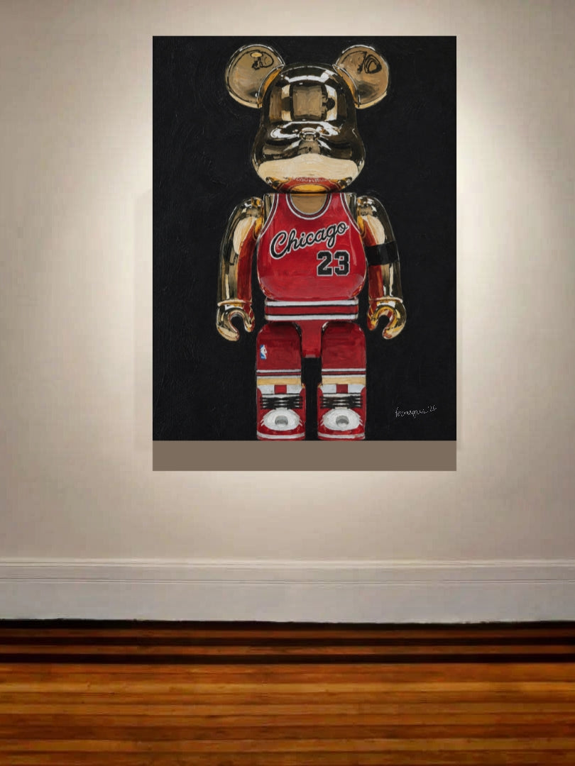 A framed wall art print showing a metallic gold bear figure wearing a red Chicago basketball jersey with the number 23, displayed on a beige wall above a wooden floor.
